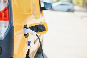 knap gebaard vent in de buurt zijn nieuw modern elektrisch auto Bij de opladen station foto