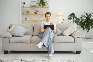 mensen, technologie en internet concept - gelukkig midden- oud vrouw met tablet pc computer Bij huis. foto