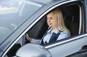 portret van bedrijf elegant middelbare leeftijd vrouw in auto. foto