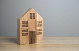 houten huis met ramen en deur, beeldje. betaalbaar huisvesting. buying een mooi hoor huis. hypotheek en lening. foto
