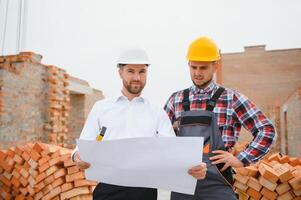 ingenieur architect met moeilijk hoed en veiligheid hesje werken samen in team Aan majoor bouw plaats foto