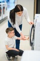 gelukkig familie buying het wassen machine in op te slaan. foto