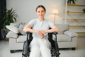 jong vrouw in rolstoel Bij huis in leven kamer. foto