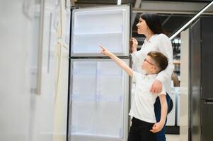 familie gebruiken huiselijk koelkast in supermarkt foto