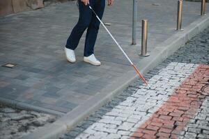 detailopname van een Blind Mens staand met wit stok Aan straat foto