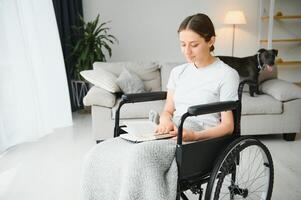 jong vrouw in rolstoel Bij huis in leven kamer. foto