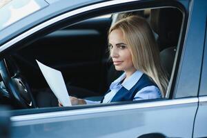 portret van bedrijf elegant middelbare leeftijd vrouw in auto. foto