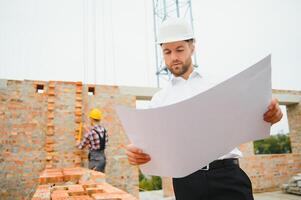 bouw concept van ingenieur werken Bij bouw plaats met blauw afdrukken. foto