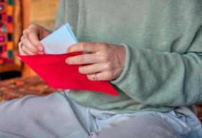 vrouw nemen brief uit van envelop, detailopname schot foto