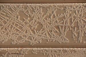 bruin hout structuur met wit vorst patronen. winter achtergrond. foto