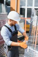 arbeiders overdracht de glas. Bij de fabriek voor de productie van ramen en deuren van aluminium en pvc foto