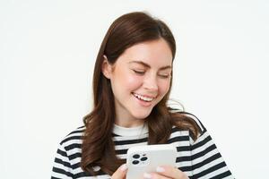 portret van meisje met smartphone lachend, gebruik makend van mobiel telefoon app, geïsoleerd Aan wit achtergrond foto