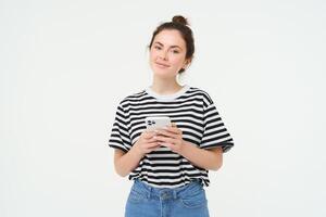 beeld van jong glimlachen vrouw, Holding mobiel telefoon, gebruik makend van smartphone sollicitatie, geïsoleerd over- wit achtergrond foto