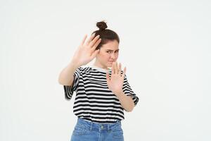 beeld van vrouw weigeren iets, verhogen handen in defensief gebaar, beschermen haarzelf, afwijzen bieden, afnemend, staand over- wit achtergrond foto