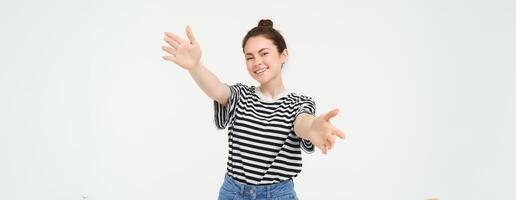 portret van schattig glimlachen vrouw strekt zich uit haar handen, bereikt naar houden iets, wil naar knuffel jij, staand over- wit achtergrond foto