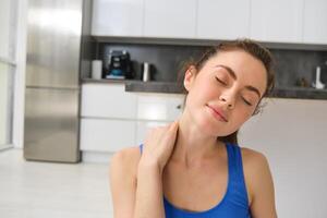 detailopname potrait van geschiktheid vrouw, doet opleiding, training van huis, masseren nek, oefening in leven kamer foto