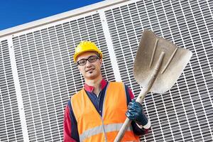 portret van een jong ingenieur vervelend een helm tegen metaal achtergrond foto