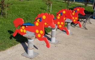 oud houten rood schommelen stoelen voor kinderen, in de stad kinderen park Aan een helder zonnig dag. foto