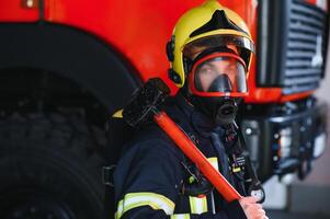 foto van brandweerman met gas- masker en helm in de buurt brand motor