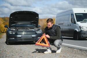 Mens met gebroken auto in de midden- van de weg. foto