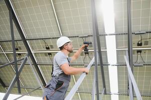 mannetje arbeider met zonne- batterijen. Mens in een beschermend helm. installeren stand-alone zonne- paneel systeem foto