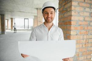 dichtbij omhoog ingenieurs werken Aan een gebouw plaats Holding een blauwdrukken.engineering en architectuur concept foto