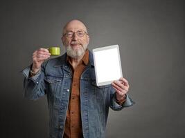 glimlachen senior Mens met een blanco digitaal tablet en een kop van koffie, onderwijs en presentatie concept foto