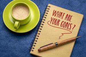 wat zijn uw doelen. een vraag geschreven in een spiraal notebook. resoluties en doel instelling concept. foto