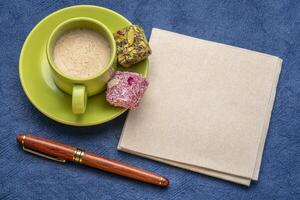 blanco servet met een pen, een kop van koffie en snoep foto