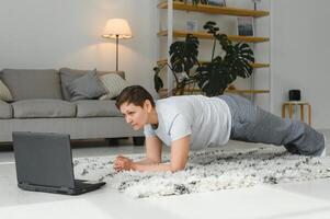 midden- oud vrouw in plank positie houdt fit in haar huis - ouderen persoon heeft pret aan het doen sport- - mentaal en fysiek welzijn concept foto