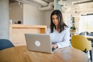 glimlachen meisje leerling studie online met skype docent, gelukkig jong vrouw leren taal luister lezing kijk maar webinar schrijven aantekeningen kijken Bij laptop zitten in cafe, ver weg onderwijs foto