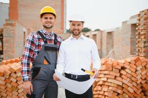 ingenieur architect met moeilijk hoed en veiligheid hesje werken samen in team Aan majoor bouw plaats foto