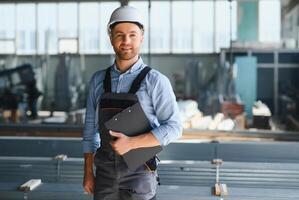 mannetje fabriek mechanica of ingenieur in veiligheid uniformen zijn werken Aan metaal boren machines in industrieel productie lijnen, staal verwerken industrie, mechanisch onderhoud. foto