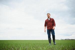 boer wandelen tussen agrarisch velden foto