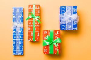 top visie Kerstmis Cadeau doos met wit en groen boog Aan oranje achtergrond foto