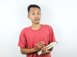 portret van een Aziatisch Mens Holding pen en schrijven boek geïsoleerd Aan wit achtergrond. foto