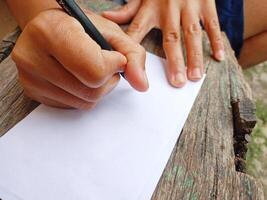menselijk handen zijn schrijven gebruik makend van pen Aan wit papier of brieven, verslag doen van papieren, financieel begroting rapporten, en accounting financieel verslag doen van planning. foto