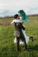 een gebaard bruidegom en een meisje met groen haar- dans en ronddraaien foto