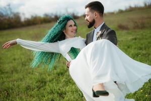 een gebaard bruidegom en een meisje met groen haar- dans en ronddraaien foto