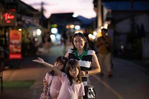 gelukkig familie, moeder en haar kinderen houding voor de camera Bij pai nacht wandelen straat, mae hong zoon, Thailand foto