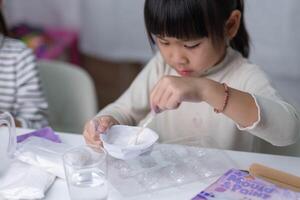 schattig weinig meisje maken diy gips en schilderij Bij huis. kinderen verf Aan gips sculpturen met familie Aan vakantie. verbeelding en creativiteit activiteiten. foto