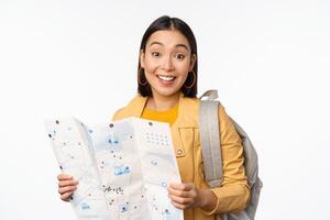 beeld van jong Aziatisch meisje toerist, reiziger met kaart en rugzak poseren tegen wit studio achtergrond foto