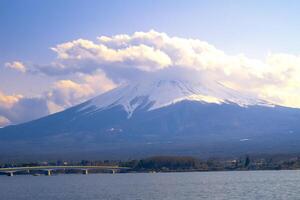 monteren fuji, groot wolken aan het bedekken de top van de berglandschap visie met water Bij kawaguchiko meer, Japan foto