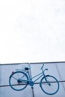 een helder blauw fiets is geschorst van de muur. ongebruikelijk landschap Aan de straat. wielersport. veloleto project in ufa. foto