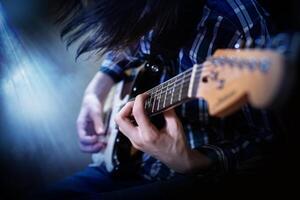 een jong mannen spelen elektrisch gitaar foto