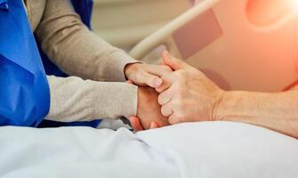 Holding geduldig handen in een ziekenhuis. familie helpen. detailopname. steun. foto