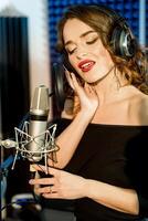 prachtig mooi vrouw vocale artiest met Gesloten ogen het zingen in de modern opname studio. portret van een mooi jong model- het zingen in studio. foto