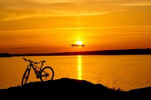 silhouet van een fiets Bij zonsondergang. dar quadcopter met digitaal camera vliegend Bij zonsondergang foto