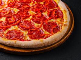 smakelijk peperoni pizza met rood klok peper foto