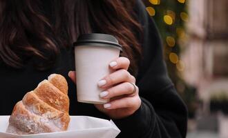 meisje Holding croissants en koffie foto